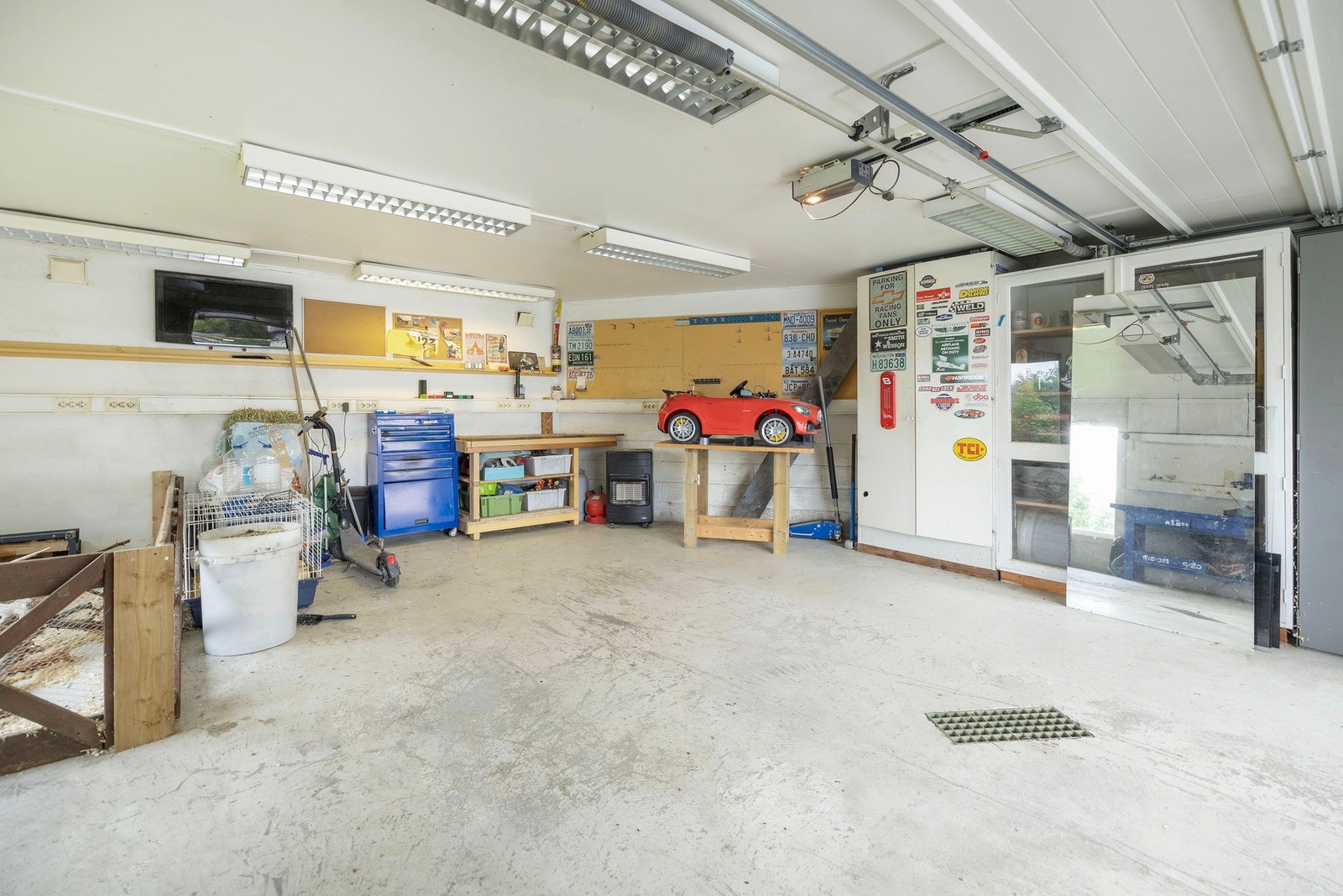 Romslig garasje med arbeidsbenk og rikelig plass til mekking og vedlikehold. Galleribilde