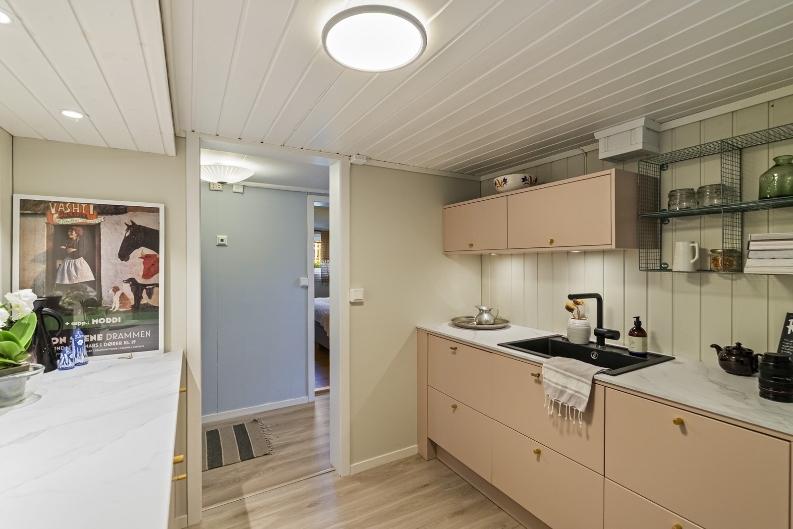 Veggene er kledd med trepanel i lyse farger som gir et lunt, skandinavisk uttrykk. Galleribilde
