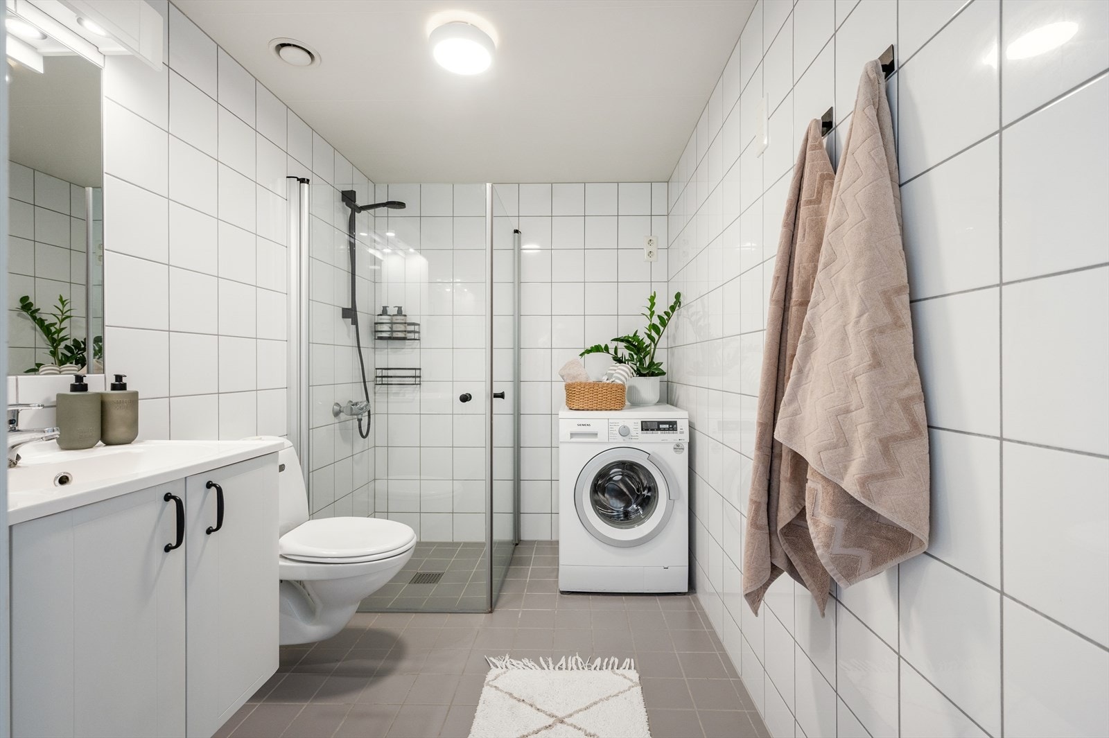 Delikat og flislagt baderom med moderne innredning og gode oppbevaringsmuligheter. Galleribilde