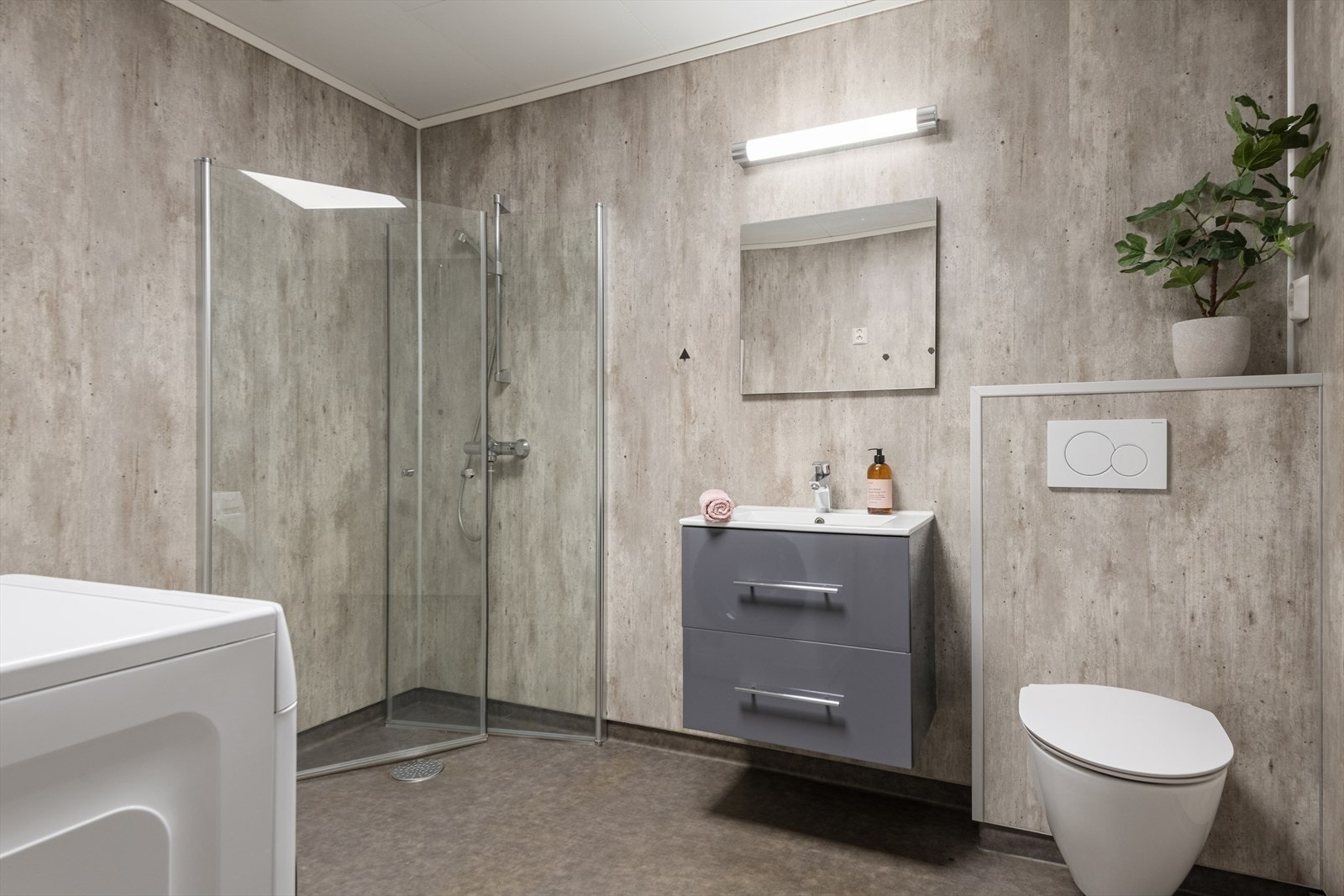 Badet ble oppgradert i 2020 - Rommet har baderomsplater på veggene og gulvbelegg med varmekabler, vegghengt toalett og dusjhjørne med innfellbare dører. Galleribilde