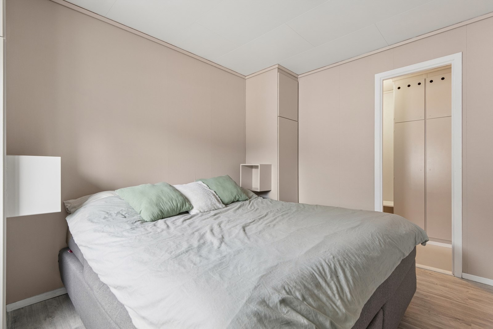Det ene soverommet er det største og har direkte tilgang til garderoben, som ligger vegg i vegg. Rommet har plass til dobbeltseng med nattbord på begge sider. Galleribilde