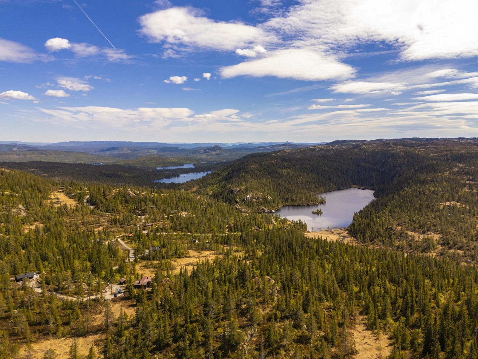 Et vidstrakt og variert landskap med skog, vann og fjell. Galleribilde