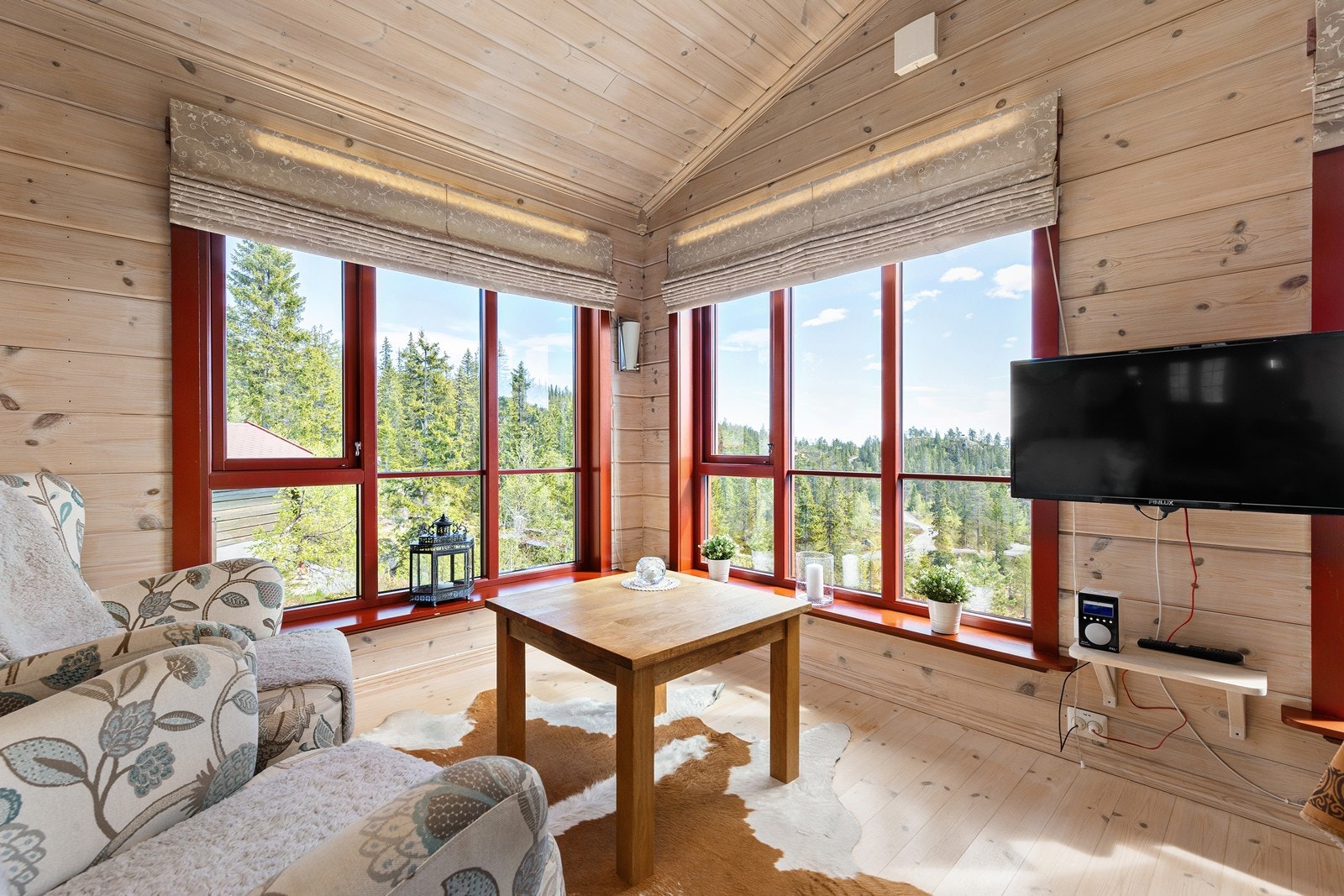 Hjørnevinduene i stuen gir rikelig med lys og rammer inn utsikten mot naturen. Galleribilde