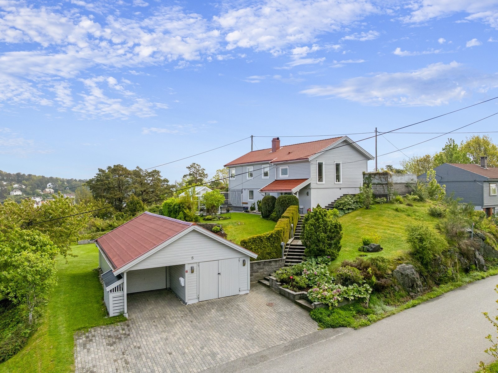 Rikelig med prydbusker og beplantning, murer og trapper samt vestvendt terrasse mot kveldssolen og utsiktsterrasse mot sydøst. Galleribilde