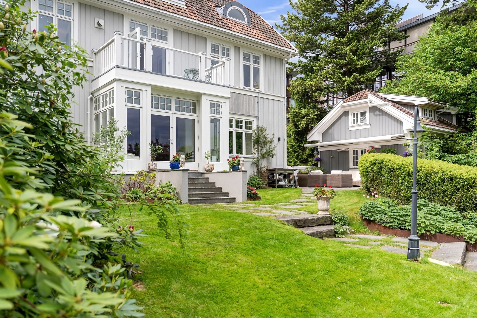 Hageanlegget er pent opparbeidet med skifer, naturstein og beplantning. Galleribilde