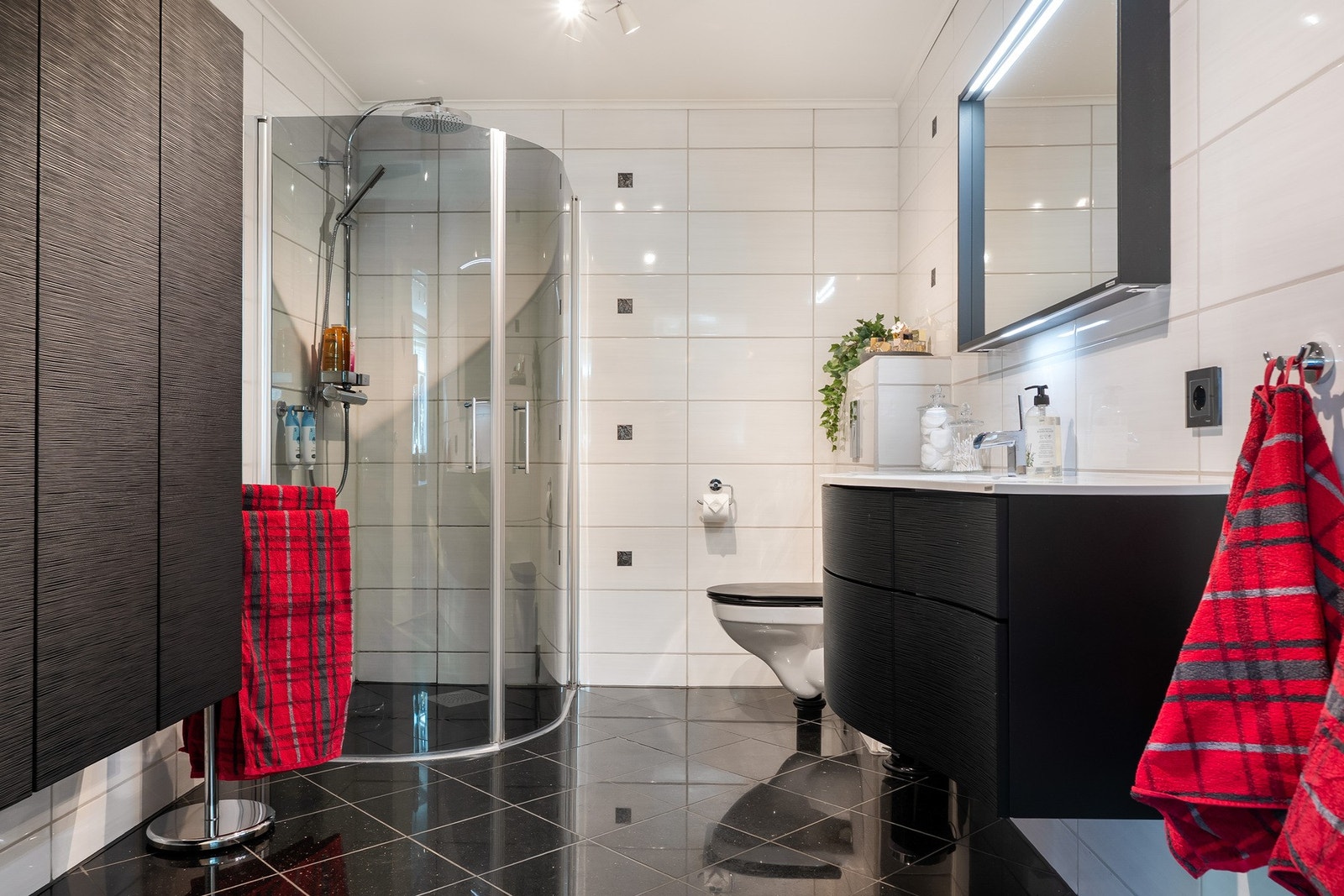 Et pent bad med dusj, wc og servantinnredning. Galleribilde