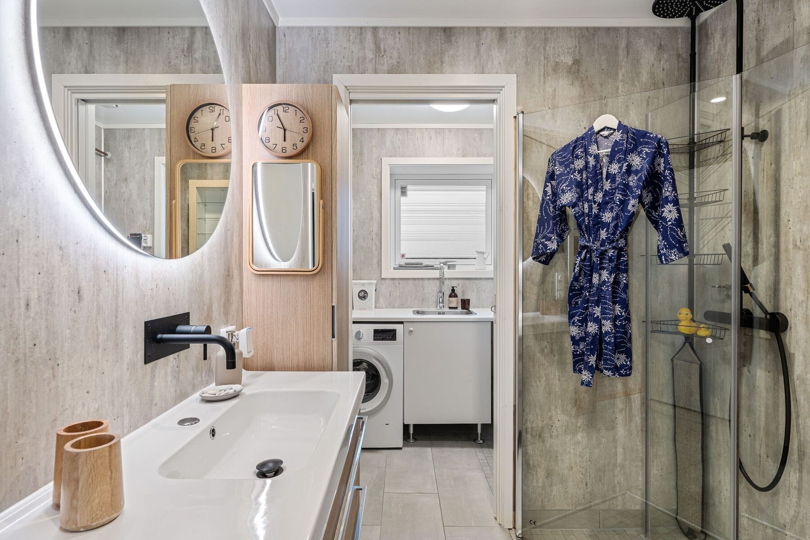 Badet er utstyrt med innfellbare dusjvegger av glass, vegghengt toalett og servant med innredning. Galleribilde