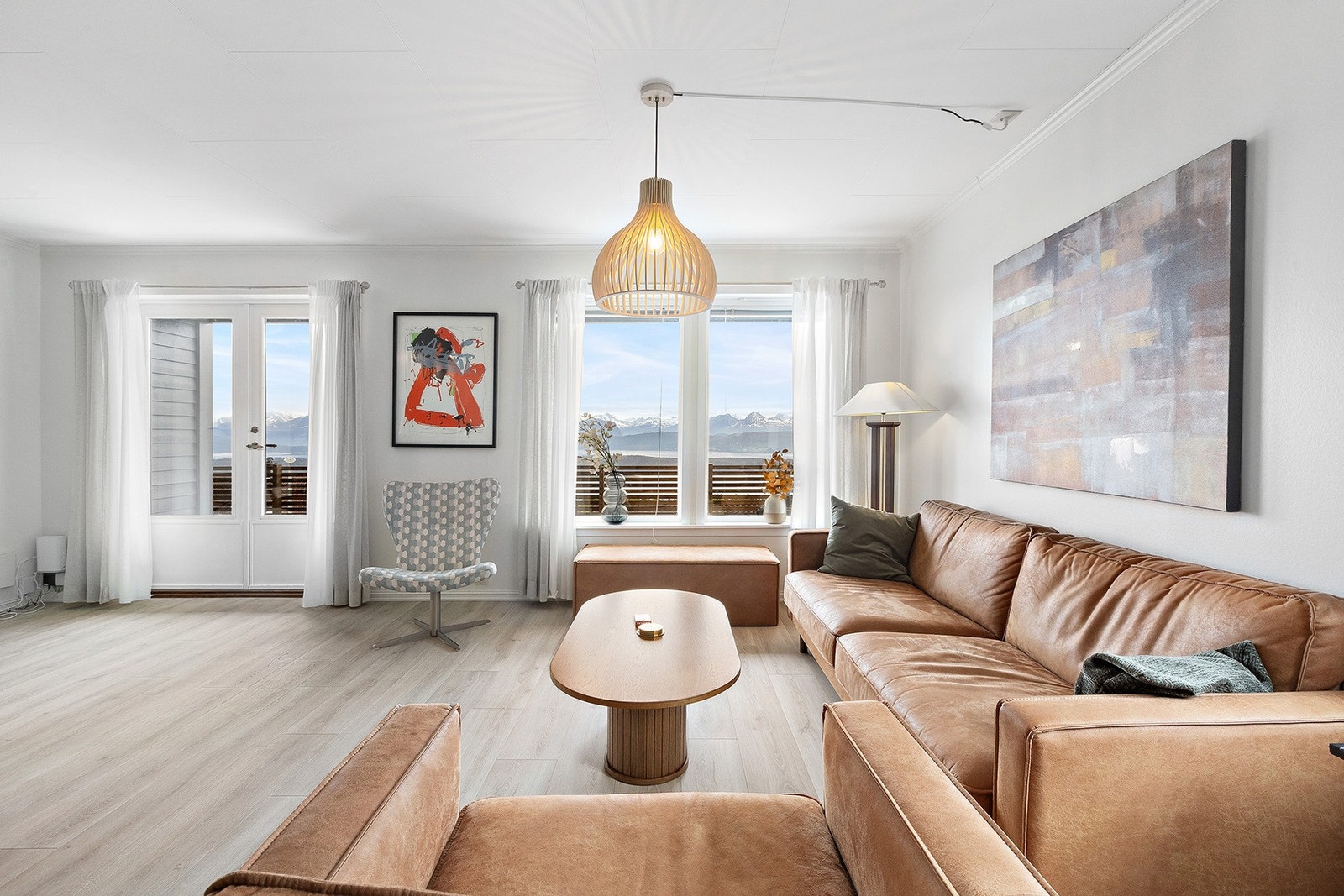 Romslig stue med lyse overflater og tilkomst til veranda. Galleribilde