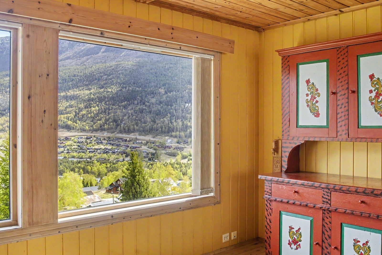 Vinduene rammer inn utsikten mot dalen og fjellene. Galleribilde