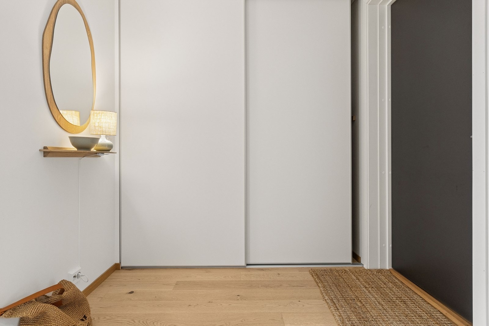 Gang med stor skyvedørsgarderobe og pene, nøytrale fargevalg. Galleribilde