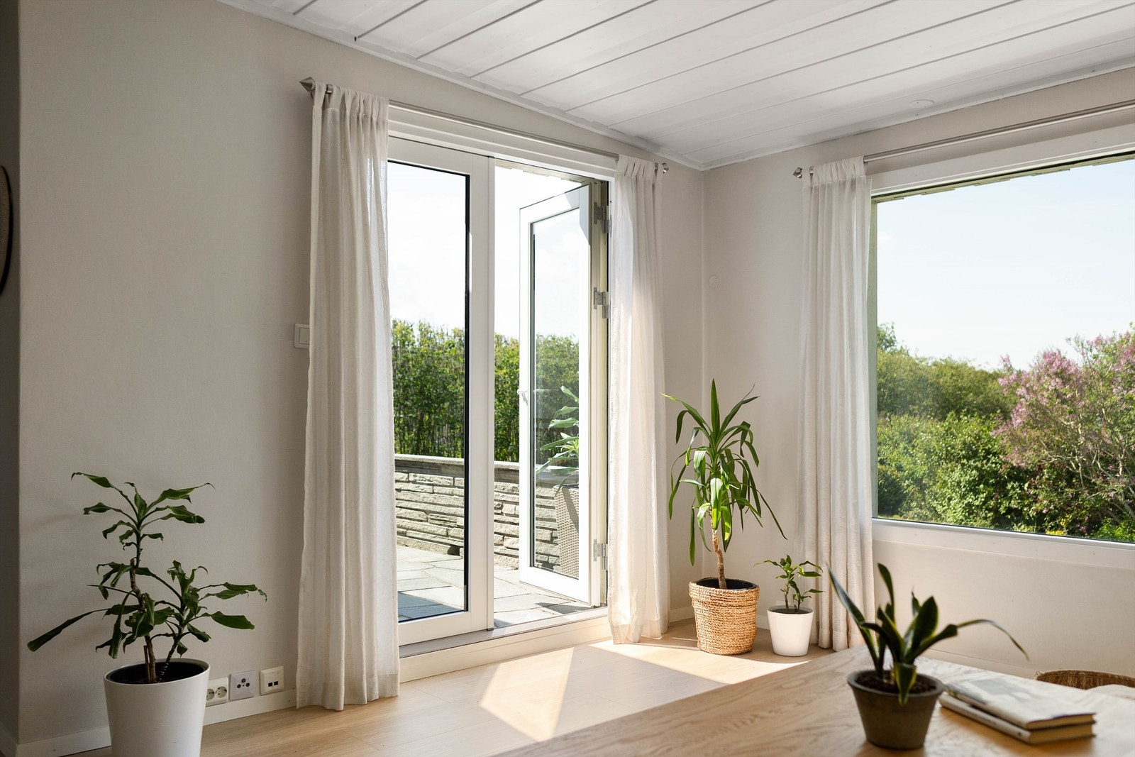 Fra stuen er det direkte utgang til en lun terrasse med skiferdekke og flotte utsyn mot den grønne hagen.. Balkongdøren har 2-lags pressglass, installert i 2026. Galleribilde