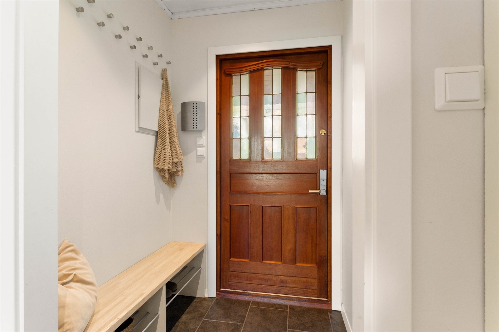 Entréen gir et hyggelig førsteinntrykk med flislagt gulv, god oppbevaringsplass og en flott hoveddør i teak. Galleribilde
