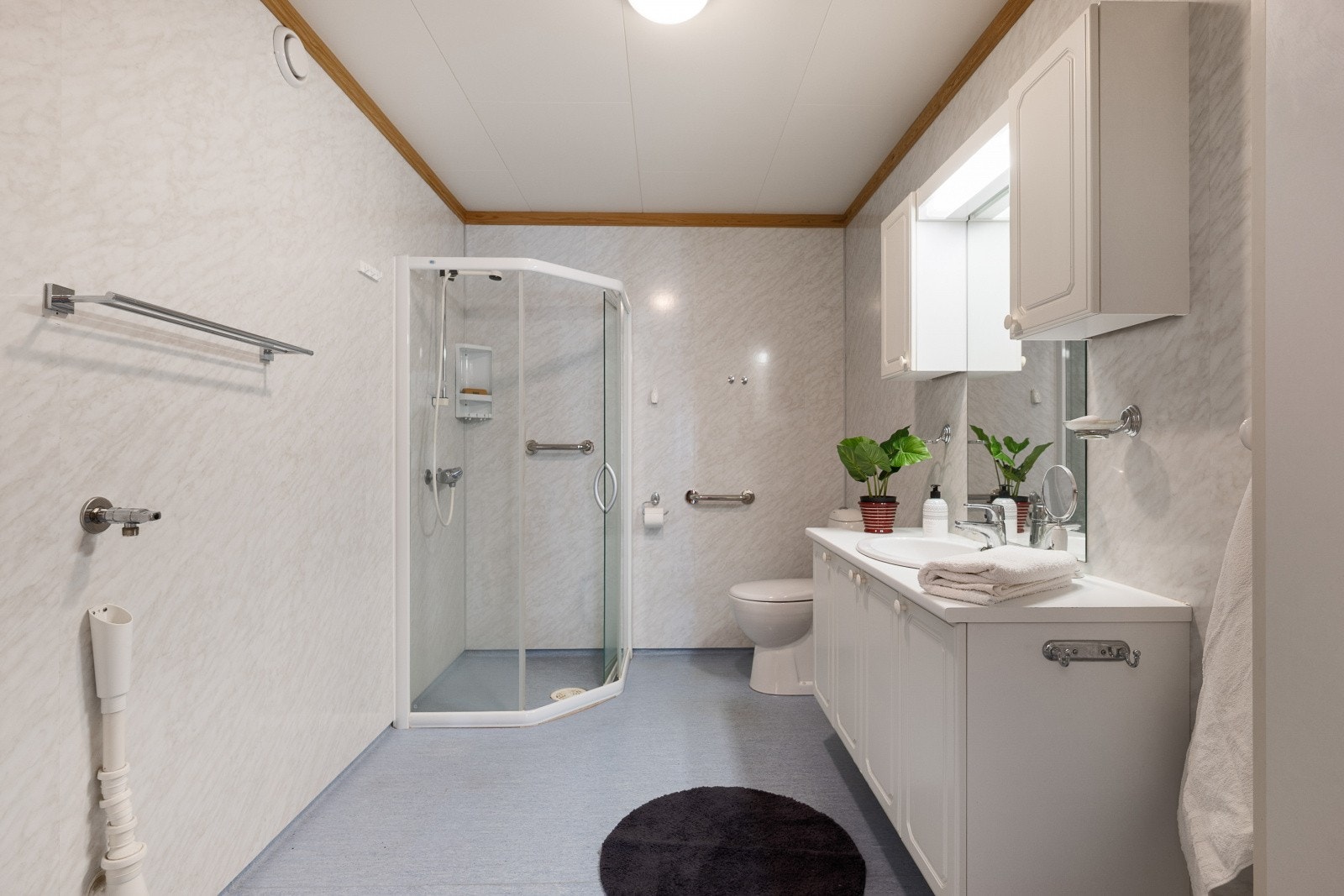 Badet har baderomsplater på veggene og belegg på gulv med gulvvarme. Galleribilde