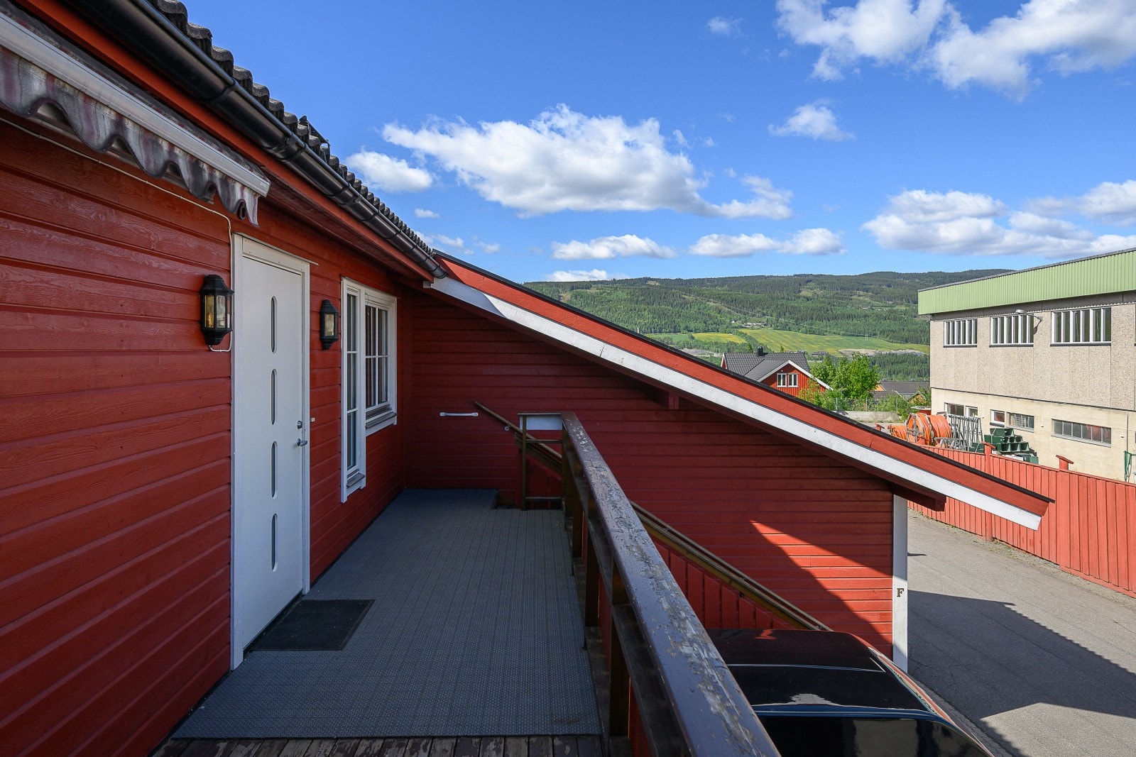 Utvendig trapp og rekkverk i treverk leder opp til leilighetens inngangsparti. Galleribilde