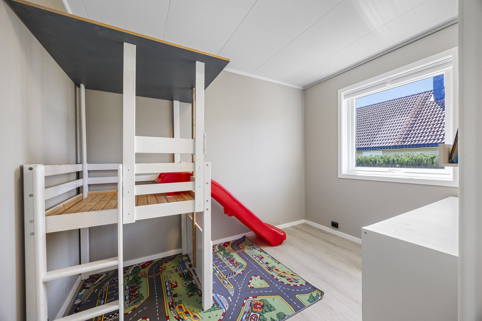 Soverom 4 har laminatgulv og slettmalte vegger, med plass til lek og oppbevaring. Galleribilde