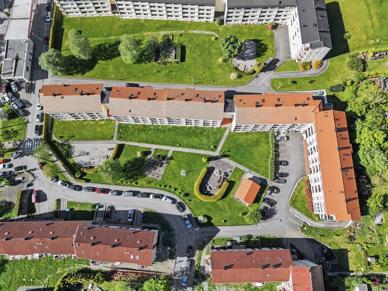 Nordre Erleveien Boliglag har store grønne fellesarealer og muligheter for parkering både på faste plasser (etter tildeling) og per nå gratis i offentlig vei. Bildet er tatt om kvelden etter arbeidstid. Galleribilde