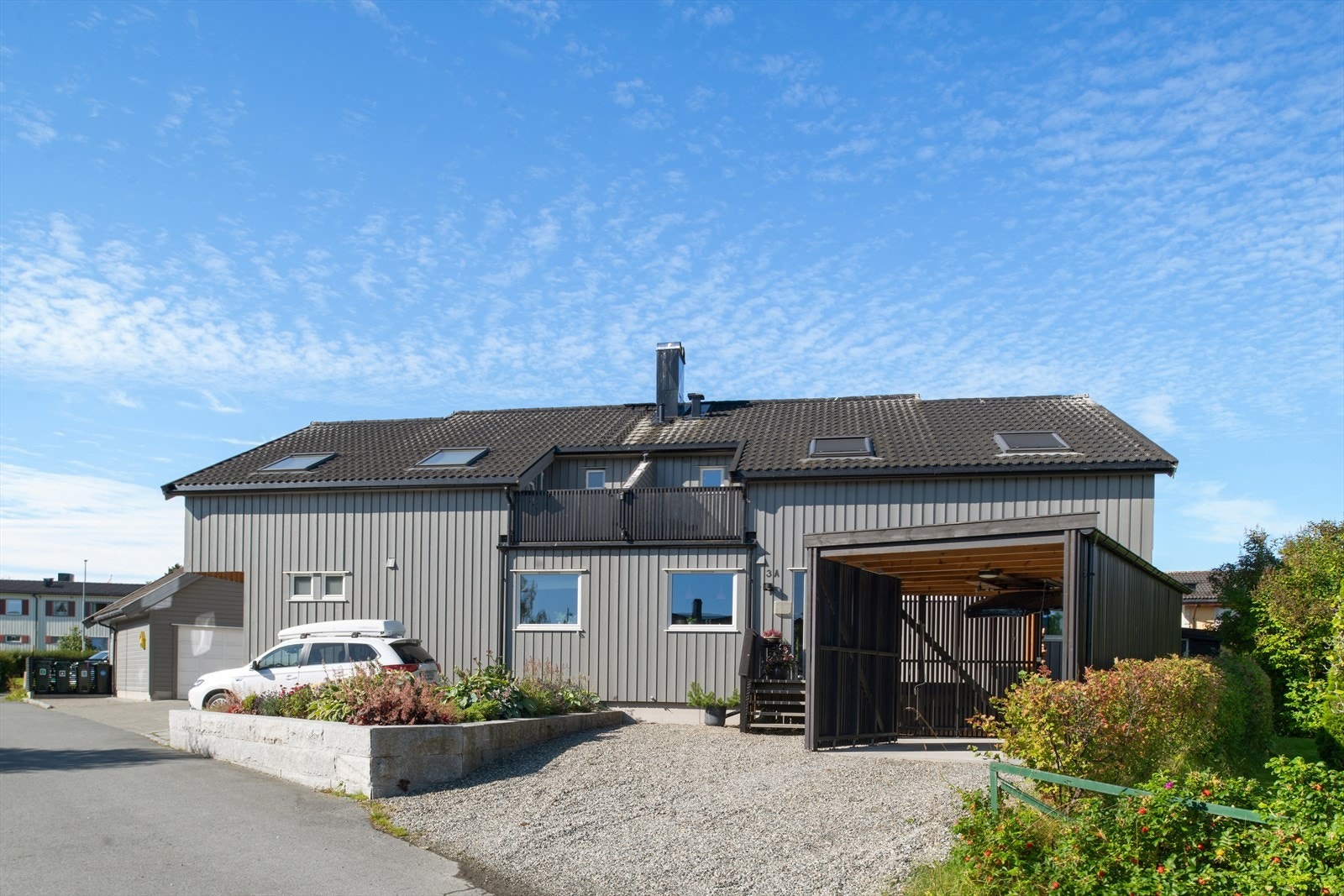 Eiendommen har en pent opparbeidet og gruset oppkjørsel med carport og plass til biloppstilling. Galleribilde