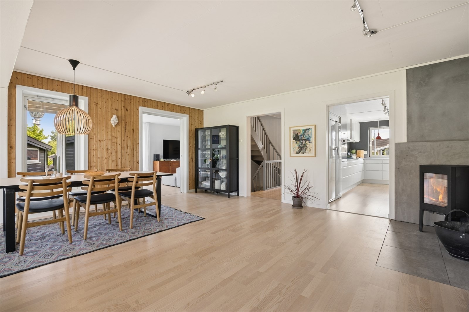 Fra spisestuen er det åpen løsning mot kjøkkenet og stuen, med en vedovn fra 2012 som et sentralt samlingspunkt. Galleribilde