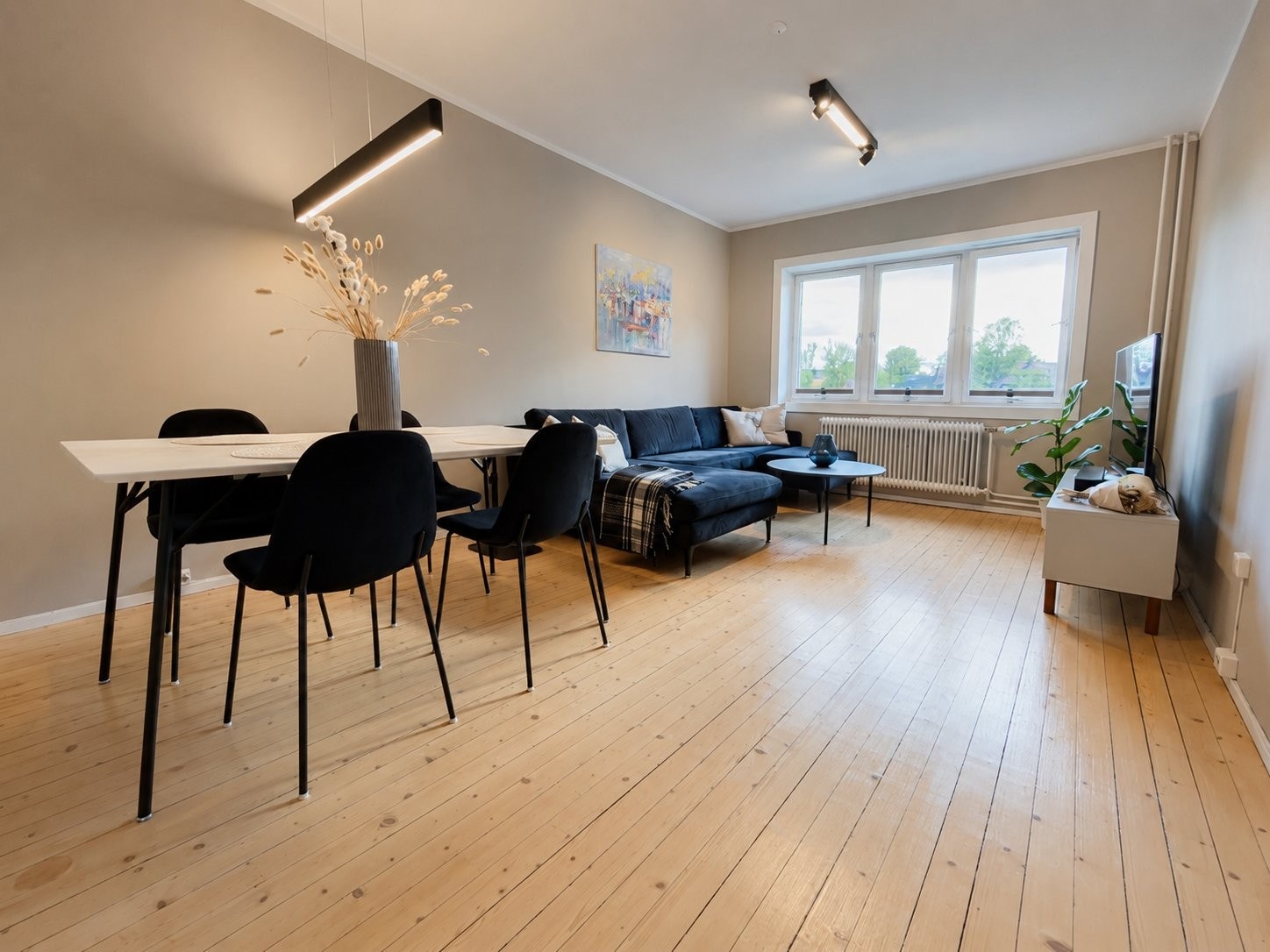 Lys og romslig stue med sittegruppe og sofa. Gulv slipt i 2024. Galleribilde