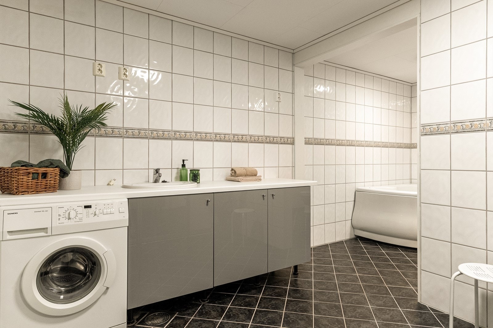 - Rommet inneholder badekar, toalett, servant med underskap, opplegg for vaskemaskin og benkeskap med laminat og vask - Galleribilde