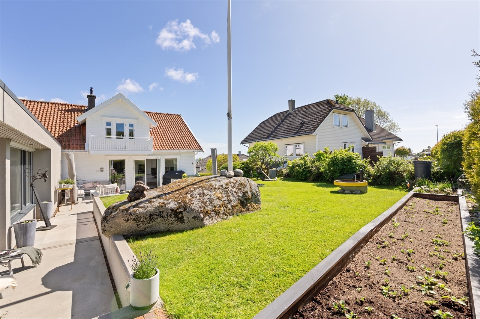 Den store hagen er pent opparbeidet med plen, hekk og beplantning. Galleribilde