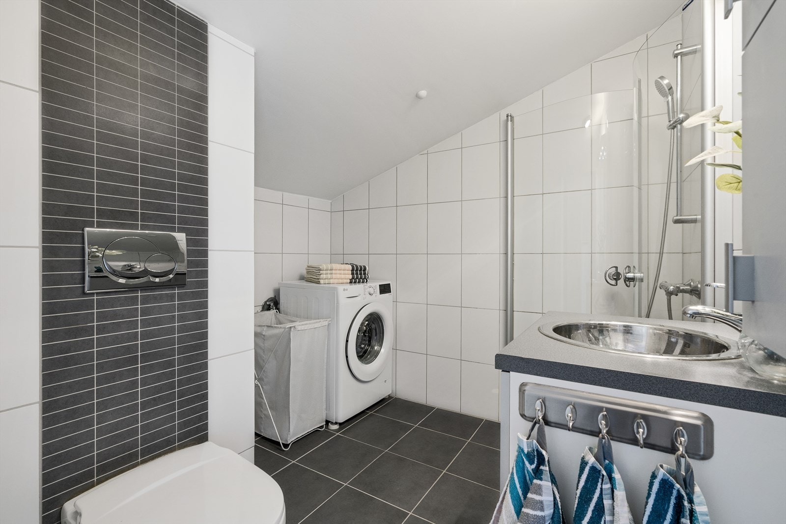 Badet har flislagt gulv med elektriske varmekabler og veggmontert toalett. Galleribilde