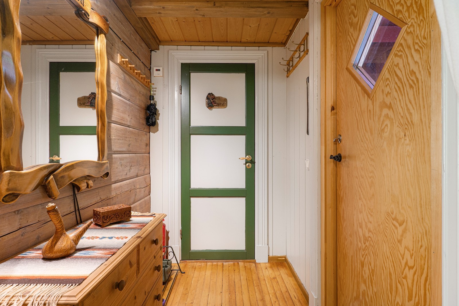 Entréen har åpen garderobeløsning med knaggrekker og skohyller. Galleribilde