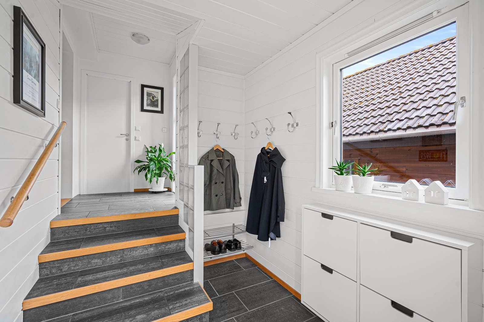 Boligen ønsker deg velkommen med en lys og romslig entré. Flislagt gulv gir et praktisk førsteinntrykk, og det er god plass til oppbevaring av yttertøy og sko. Galleribilde