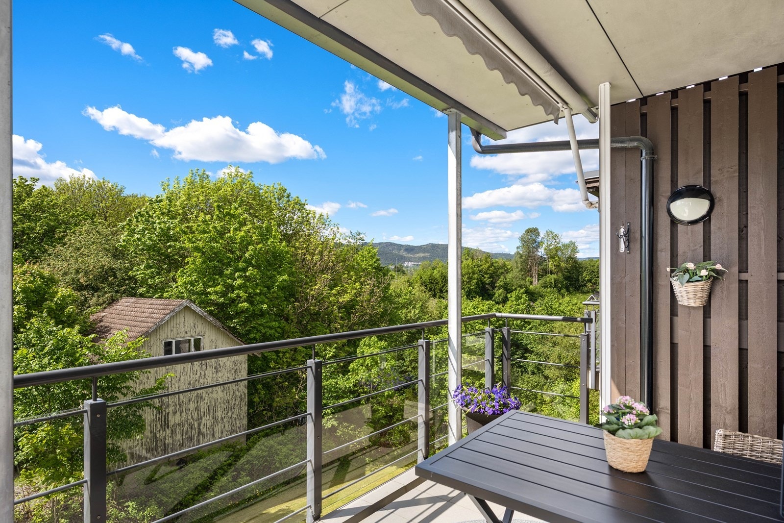 Terrassen har flislagt gulv og rekkverk i stål og glass. Galleribilde