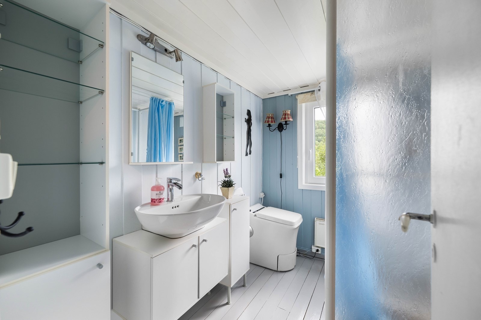 Badet har innredning som servantmøbel med skap, dusjkabinett og biotoalett. Galleribilde