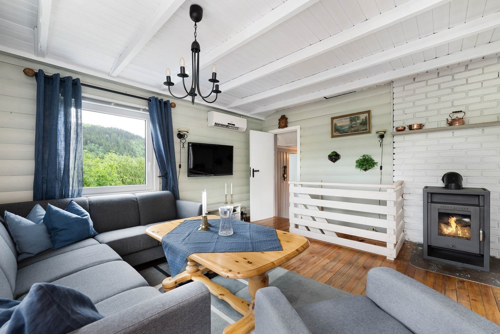 Av muligheter til oppvarming finner man både vedovn og varmepumpe her i stuen. Galleribilde