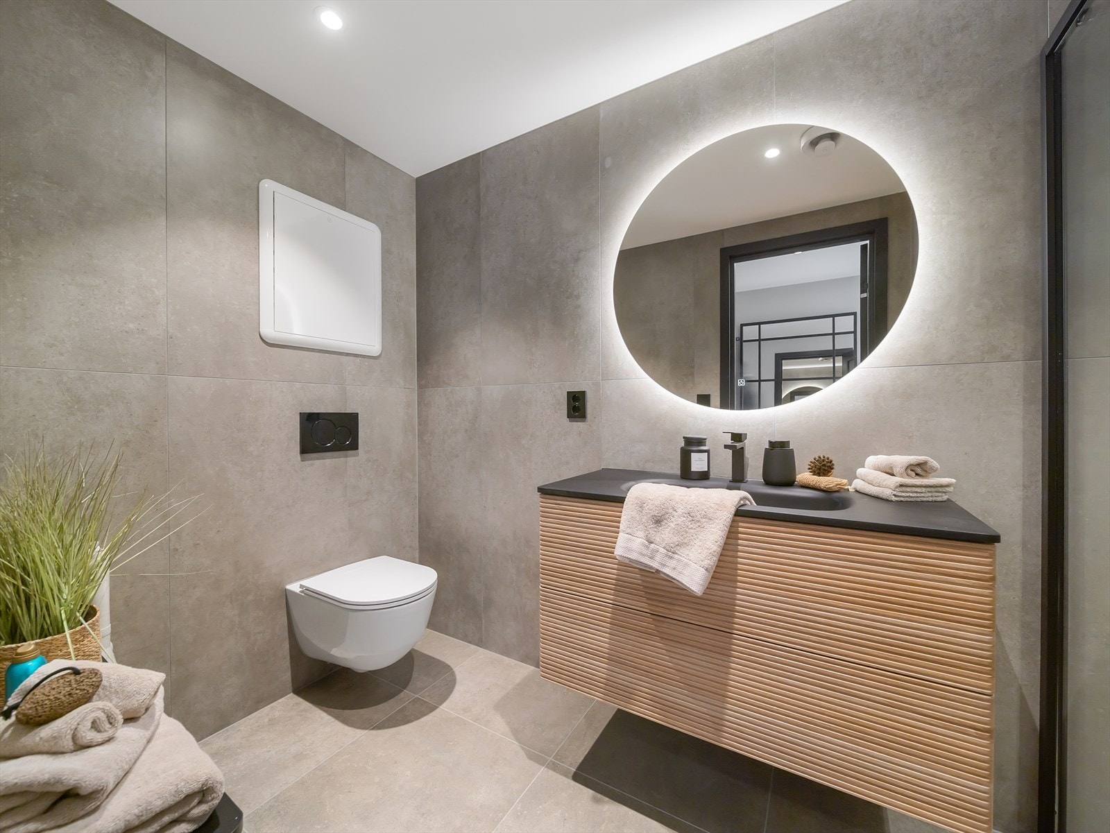 Badet er utstyrt med innredning med nedfelt servant, veggmontert toalett og dusjvegger/hjørne av glass. Det er opplegg til vaskemaskin. Galleribilde