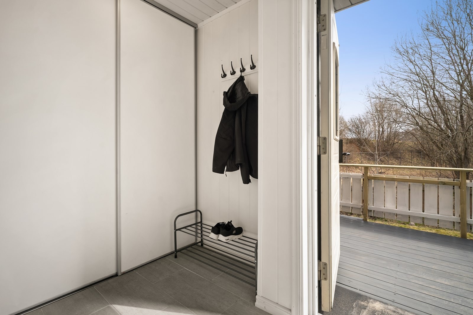 Flislagt entré med skyvedørsgarderobe. Galleribilde