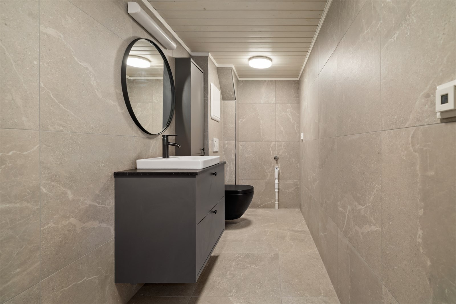 Badet inneholder servant med innredning, vegghengt toalett og dusjhjørne. Det er opplegg for vaskemaskin på bad i kjeller. Galleribilde