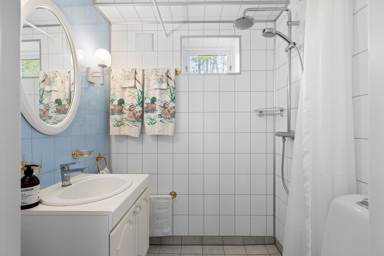 Boligen har et bad i hver etasje - her har du servant på servantinnredning, speil, gulvstående toalett og dusjhjørne. Galleribilde