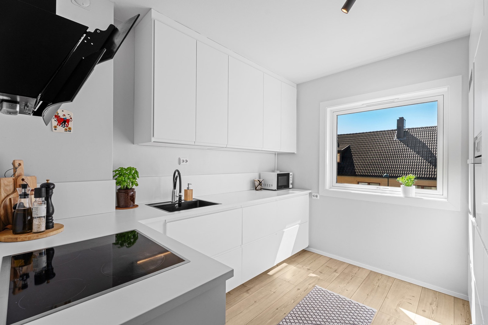 Lyst nyere kjøkken fra IKEA, med god benk- og skapplass. Galleribilde