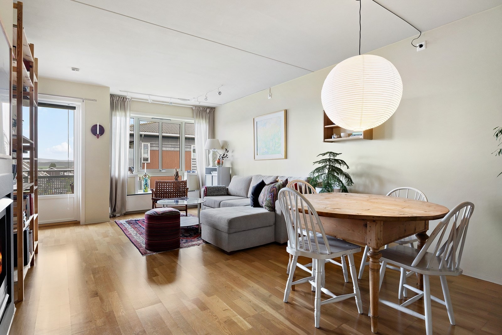 Åpen stue- og kjøkkenløsning med plass til sofa, spisebord, skjenk, hylleløsninger og TV. Galleribilde
