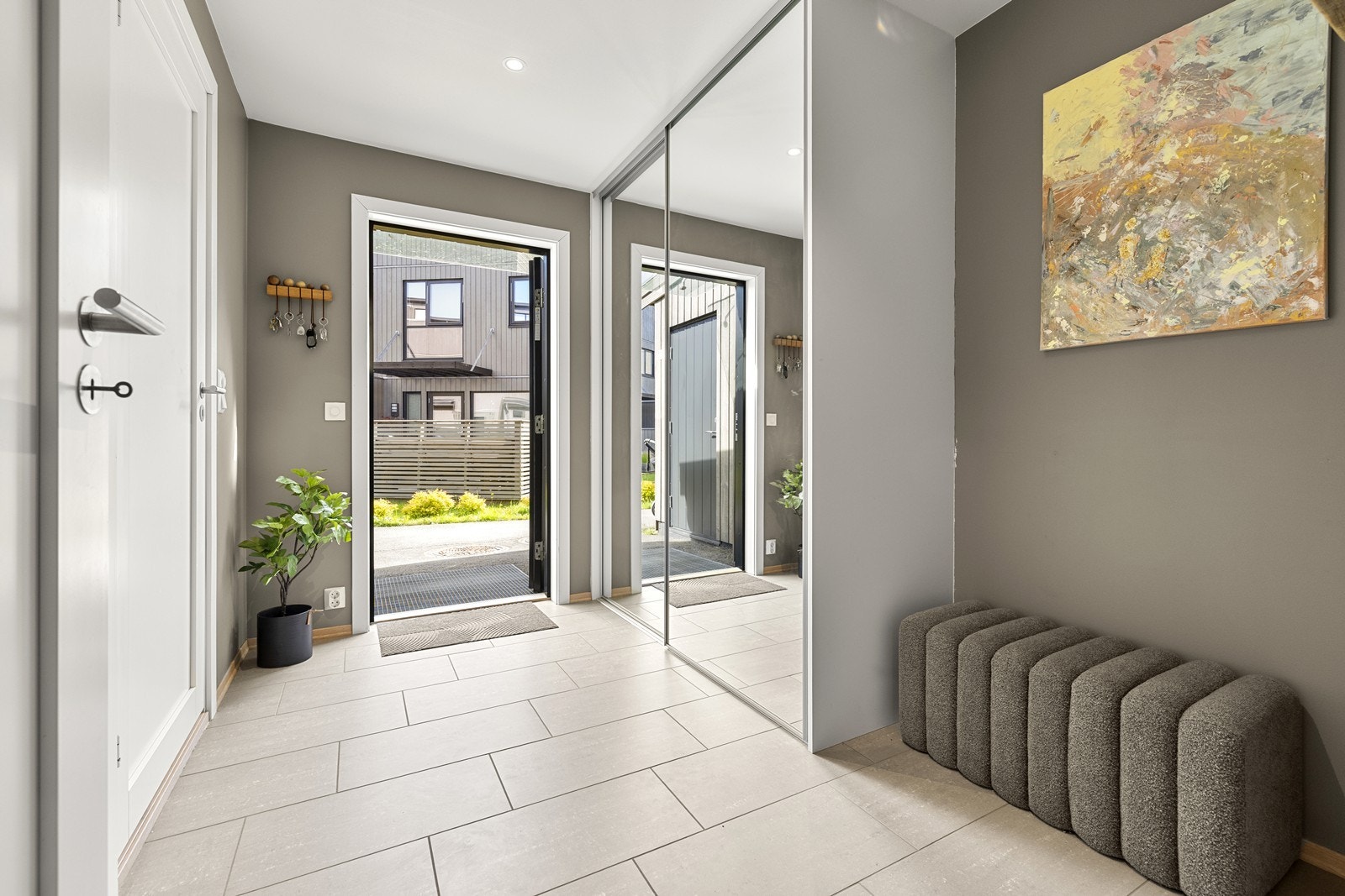 Velkommen inn! Entréen er romslig med flislagt gulv og vannbåren gulvvarme. Skyvedørsgarderobe gir rikelig med oppbevaringsplass. Galleribilde