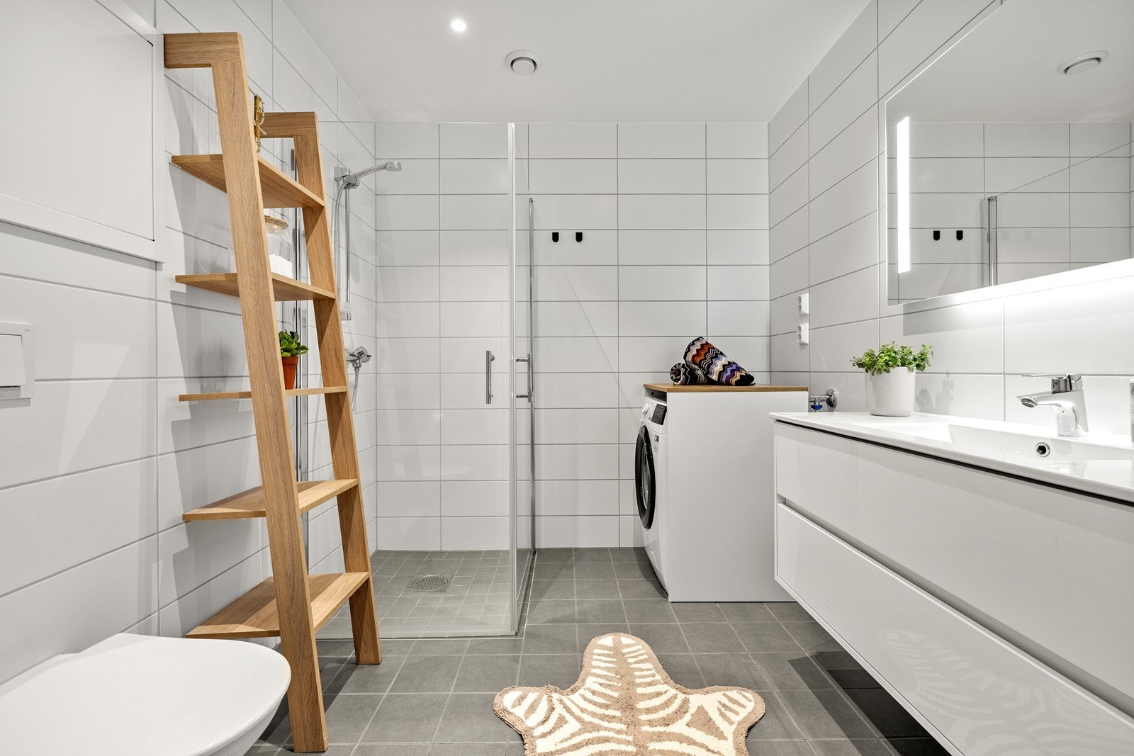 Badet i første etasje har flislagt gulv med vannbåren varme, vegghengt toalett og dusjhjørne. Galleribilde