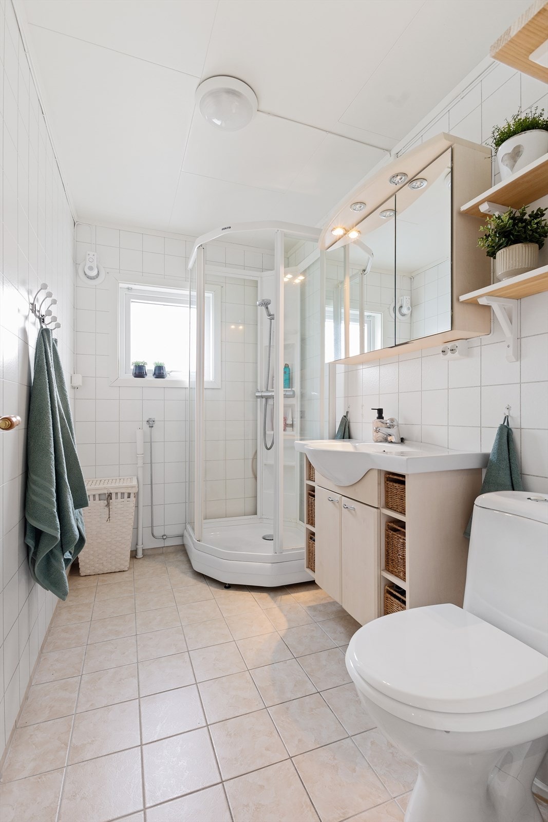 Flislagt bad med elektriske varmekabler i gulvet. Rommet har dusjkabinett og opplegg for vaskemaskin. Galleribilde