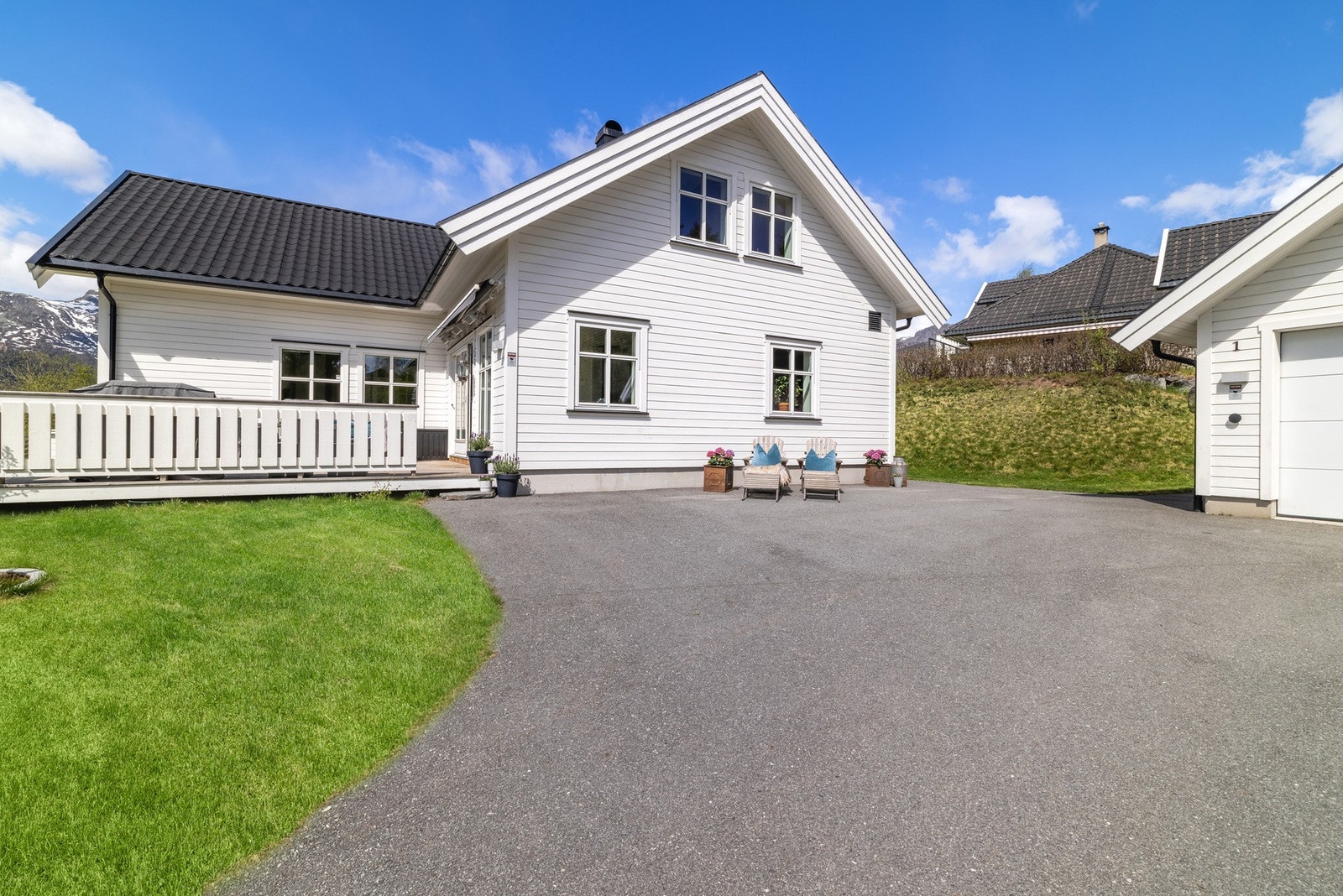 Boligen med asfaltert gårdsplass og dobbelgarasje med motorstyrt leddport - god plass til flere biler på tomten Galleribilde