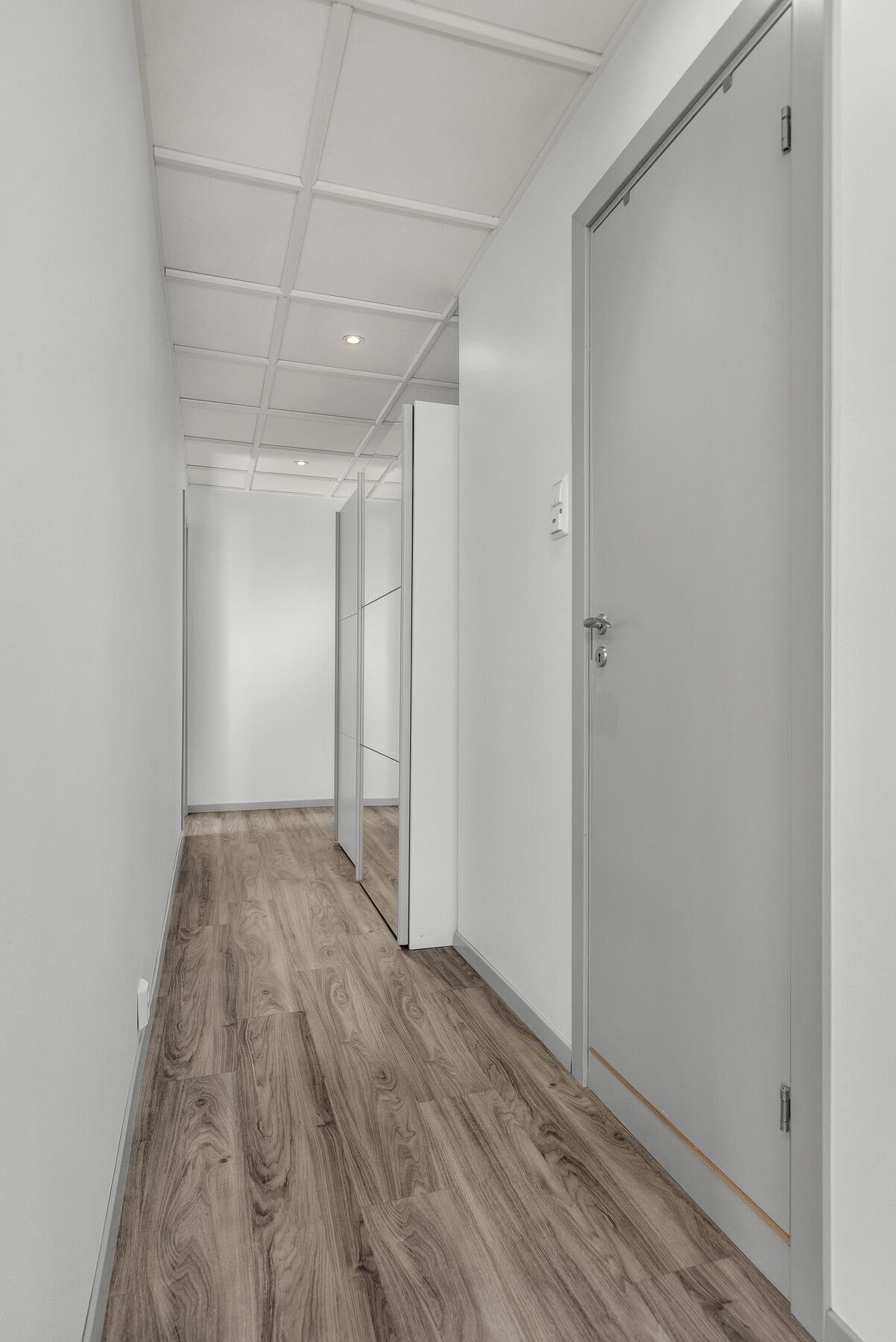 Gangen har laminatgulv og systemhimling, som er gjennomgående i flere av rommene. Galleribilde