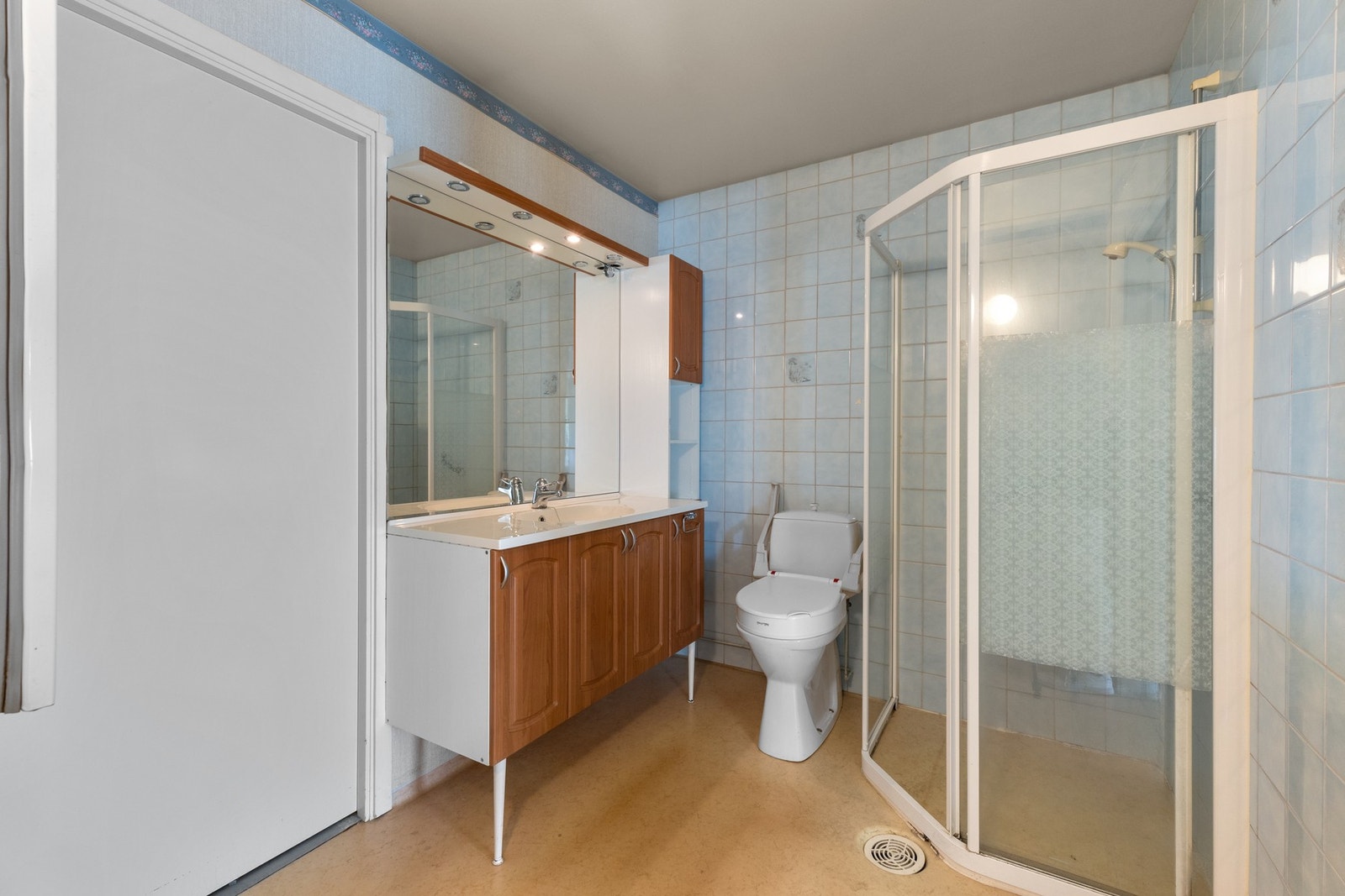 Badet har vamekabler i gulv og veggoverflater av fliser og tapet. Galleribilde