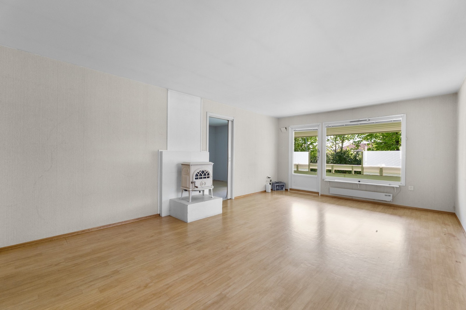Stuen er lys og romslig med vedovn. Rommet har god plass til både sofa, spisebord og tv-løsning. Galleribilde
