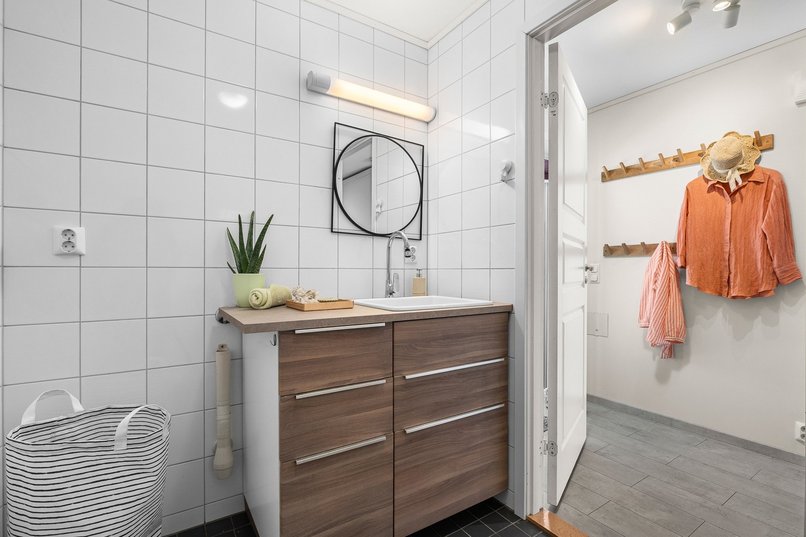 Badet er innredet med servantinnredning, veggmontert toalett og opplegg for vaskemaskin. Galleribilde