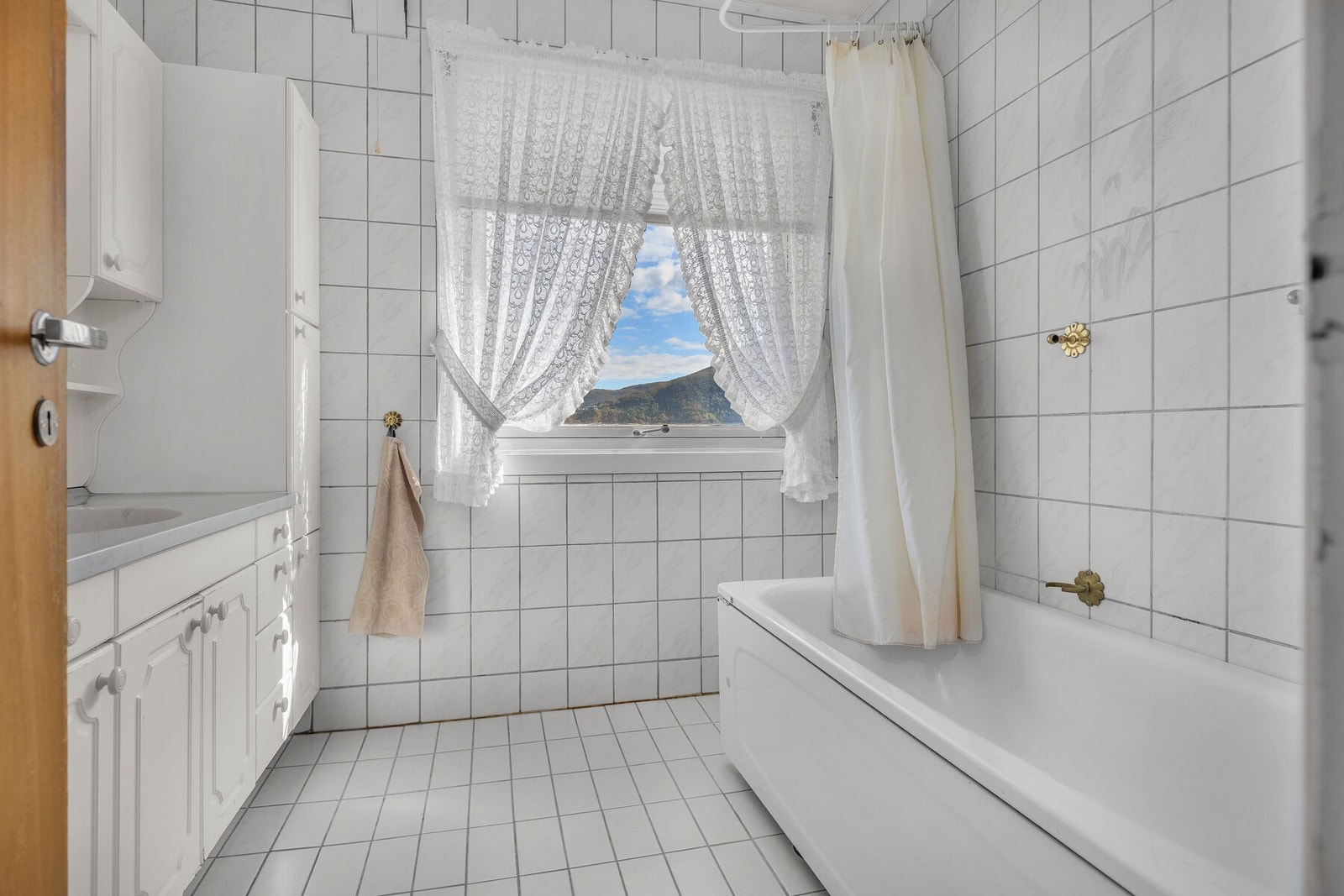 Badet i første etasje har fliser på gulv og vegger, og er utstyrt med badekar. Galleribilde