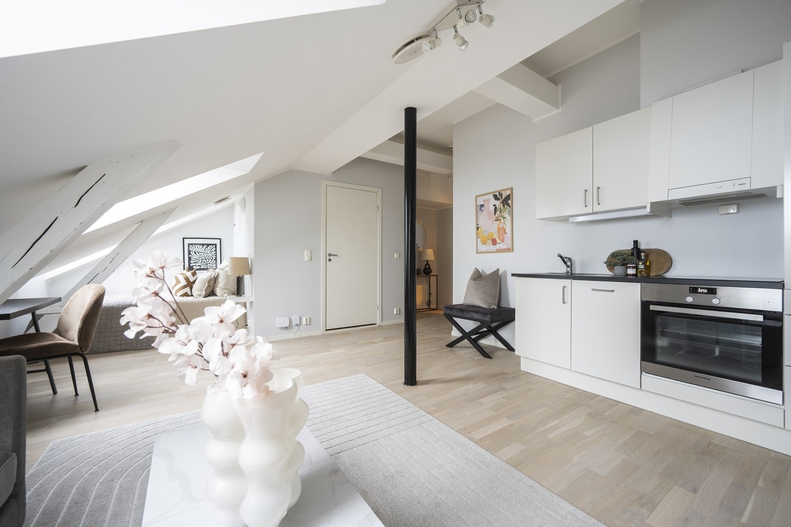 Innredning med malte slette overflater og benkeplate i laminat. Belysning over benkeplaten og nedfelt oppvaskkum og ettgreps blandebatteri. Galleribilde