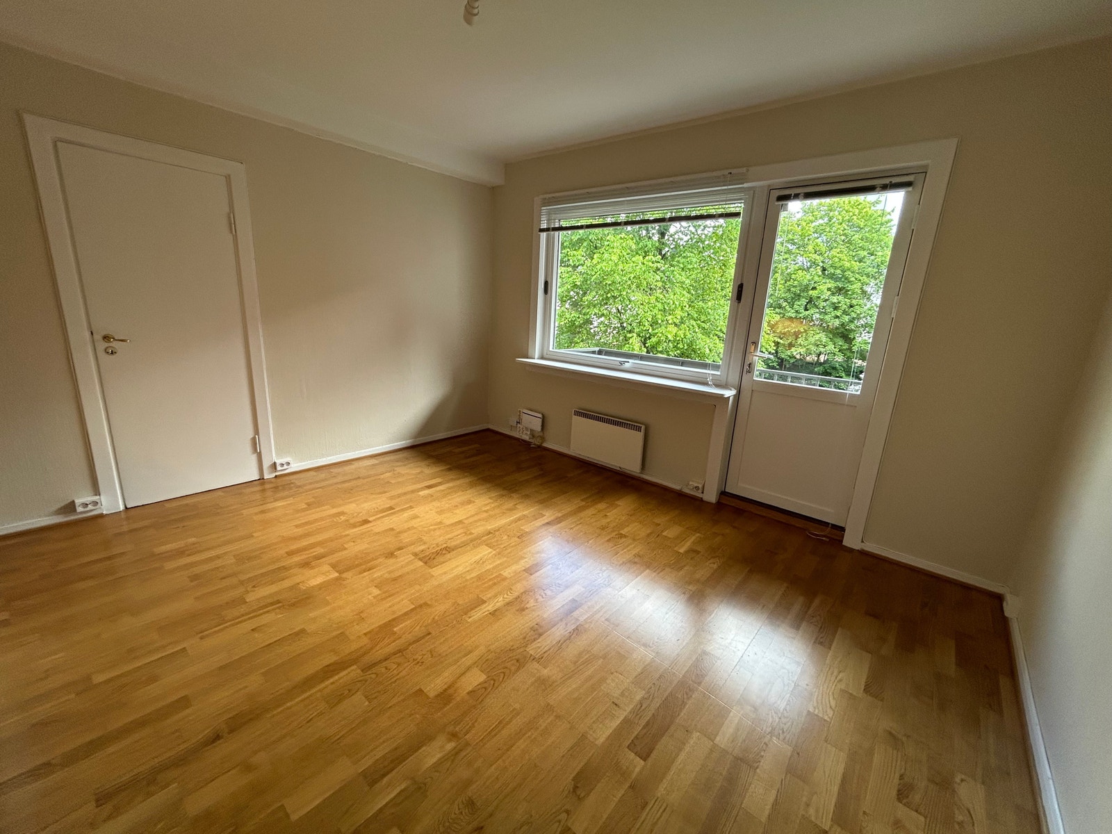 Koselig oppholdsrom med åpen kjøkkenløsning, og utgang til balkong mot lys, åpen og stille bakgård. Galleribilde