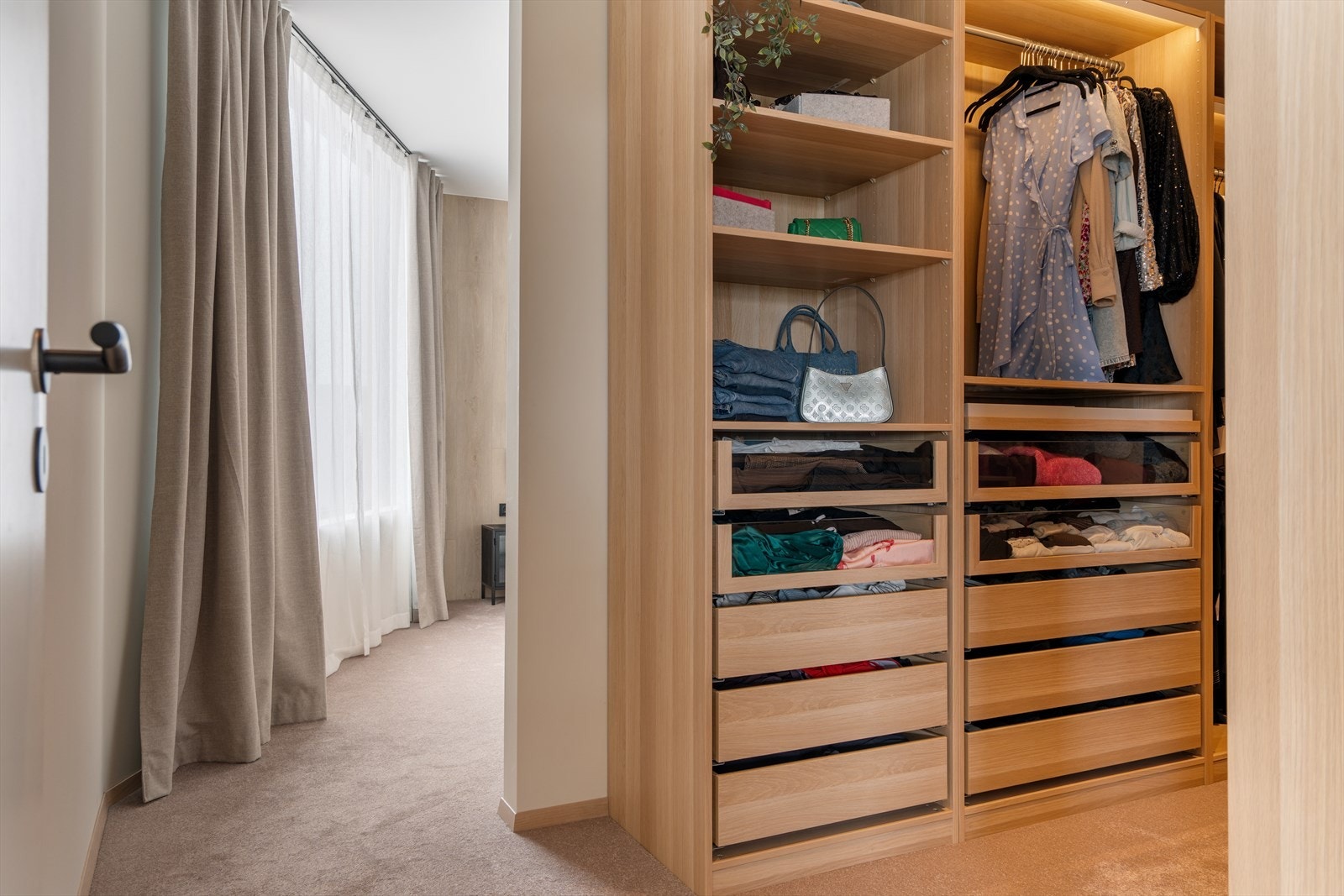 Bak en skjermende vegg finner man en åpen garderobeløsning/walk-in closet. Galleribilde