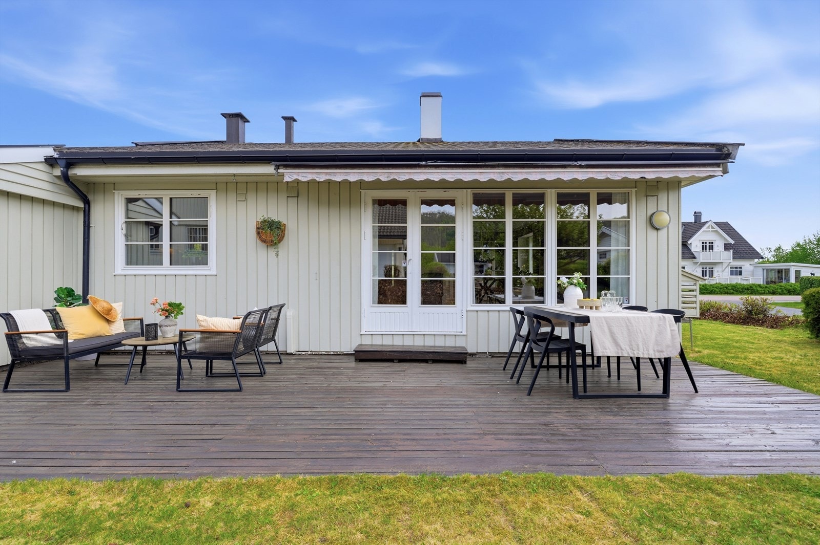 Terrassen strekker seg langs store deler av husets bakside og gir rikelig med uteplass. Galleribilde
